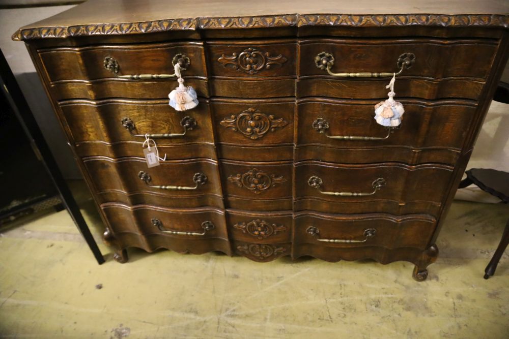 A 20th century French oak commode, fitted four long drawers with carved decoration, width 122cm, depth 43cm, height 92cm